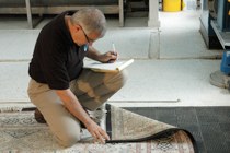 Murray Peacock inspecting a rug as it is brought into to rug washing plant in Kemptville.