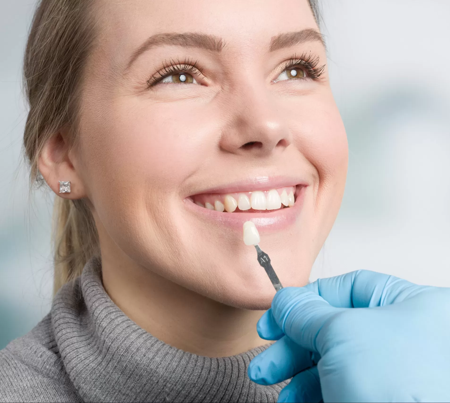 Close,Up,Of,Dentist,Using,Shade,Guide,At,Woman's,Mouth